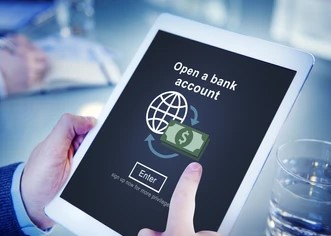 A person using a laptop in a library setting, with a Payplex sign in the background